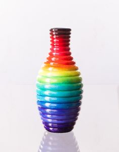 a multicolored vase sitting on top of a white table