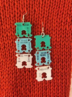 two pieces of metal are attached to the same pair of earrings on a red sweater