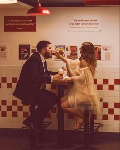 Engaged couple sharing burger in five guys fast food restaurant Engagement Photos Fast Food, Grocery Store Wedding Photos, Burger Engagement Photos, Mcdonalds Engagement Shoot, Fast Food Wedding Photos, Crazy Engagement Photos, Couple Diner Photoshoot, Retro Diner Engagement Photos