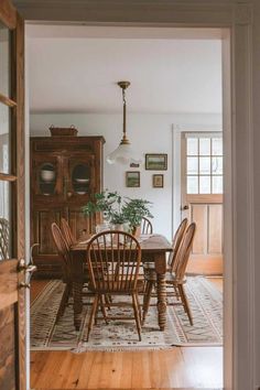 a dining room table and chairs in front of an open door