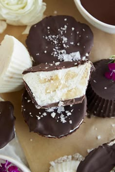 chocolate covered desserts with white frosting and sprinkles on a table