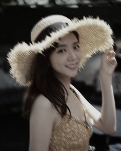 a woman wearing a hat and smiling for the camera