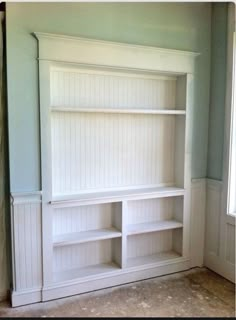 a white bookcase in the corner of a room