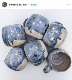 five blue and white ceramic vases with stars on them