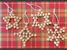 four wooden beads are arranged in the shape of snowflakes on a plaid tablecloth