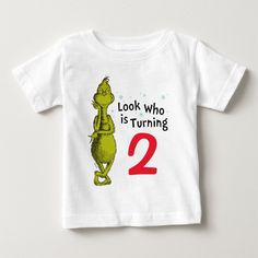 a white t - shirt with the words, look who is turning 2 on it