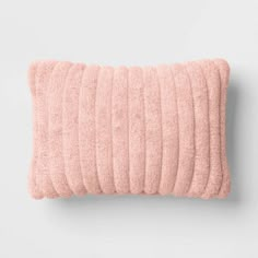 a pink pillow on a white wall