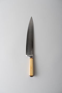 a knife with a wooden handle on a white surface