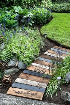 a wooden walkway made out of pallets in the garden