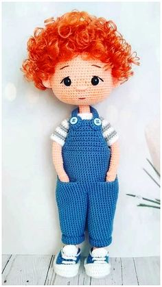 a crocheted doll with red hair and overalls