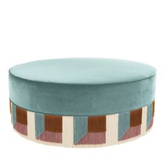 a round ottoman with blue velvet and multicolored stripes on the bottom, sitting on a white background