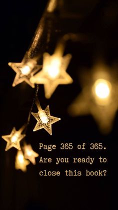 some stars are hanging from a string with lights in the background that says, page 35 of 365 are you ready to close this book?