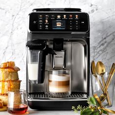 an espresso machine sitting on top of a counter next to some coffee cups