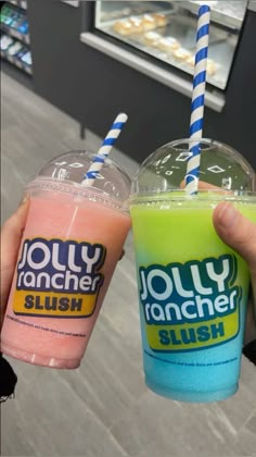 two people holding up drinks in front of each other with blue and pink straws