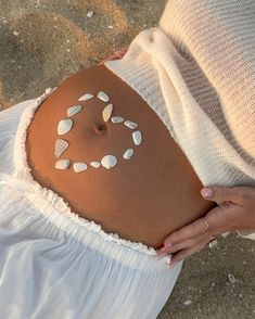 a pregnant woman with shells painted on her stomach