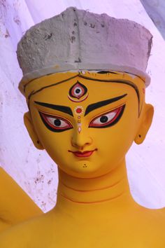 a yellow statue with red eyes and white hair