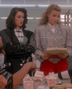 three women standing around a table with food on it