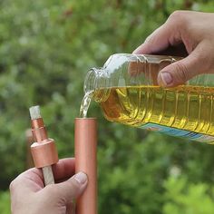 a person is pouring oil into a bottle