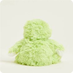 a green stuffed animal sitting on top of a white surface