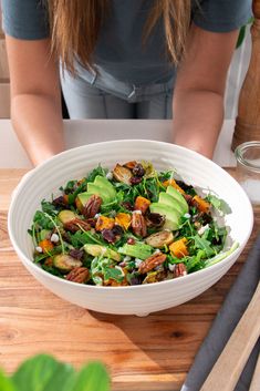 a woman sitting at a table with a salad in front of her