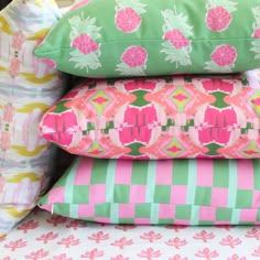 four pillows stacked on top of each other in different colors and patterns, with pineapples printed on them