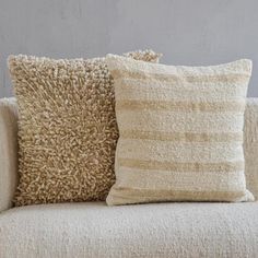 two pillows sitting on top of a couch