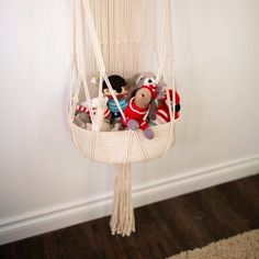 two stuffed animals in a hammock hanging from the wall