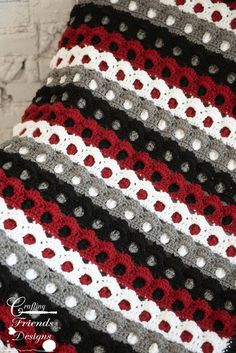 a crocheted blanket with red, white and black stripes