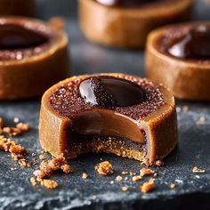 some kind of dessert that is sitting on a black surface with other pastries in the background