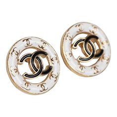 These Chanel CC round stud earrings feature a gold tone round cut-out detail stud earring with white enamel trim accented with mini gold tone CC's and one large black enamel CC logo in the center with post back closures.Origin: ItalyCondition: New and never wornAccompanied by: Chanel box, jewelry box, carebook, retail UPCMeasurements: 0.6" x 0.6" Designer White Earrings For Formal Occasions, Classic Gold Enamel Earrings, Luxury White Enamel Earrings, Elegant White Enamel Earrings, Luxury Silver Enamel Earrings, Luxury White Pierced Earrings, White Enamel Round Earrings, White Round Enamel Earrings, Formal White Jewelry With Black Enamel