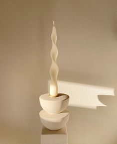 a tall white candle sitting on top of a table