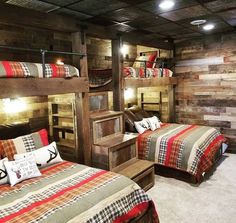 two beds in a room with wooden walls and bunk beds on each side, one is made out of wood planks