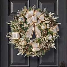 a wreath on the front door decorated with gold and silver bows, pine cones, evergreens and bells