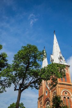 an old church steeple with trees in the foreground