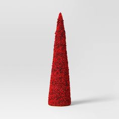 a red cone shaped object made out of small balls on a white surface with one end facing the camera