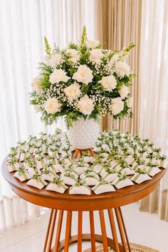 a bouquet of white flowers sitting on top of a wooden table