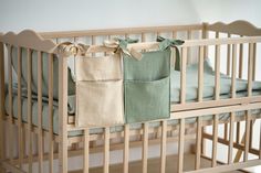 a baby crib with two blankets hanging from it's sides