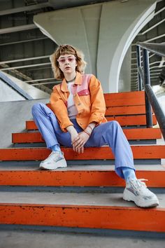 a young man sitting on top of orange steps