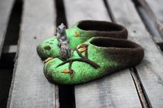 a pair of green slippers sitting on top of a wooden bench next to a squirrel figurine