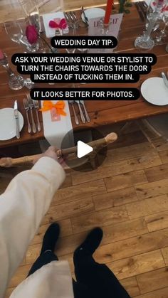 a person standing in front of a wooden table with white plates and silverware on it