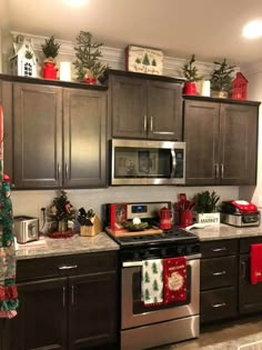 a kitchen decorated for christmas with holiday decorations on the counter top and oven in the middle