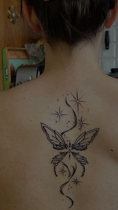 the back of a woman's neck with a butterfly tattoo on it