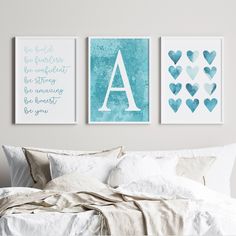 three blue and white prints on the wall above a bed