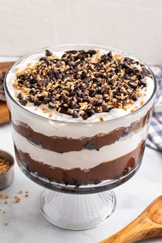 a layered dessert in a glass dish with chocolate chips on top