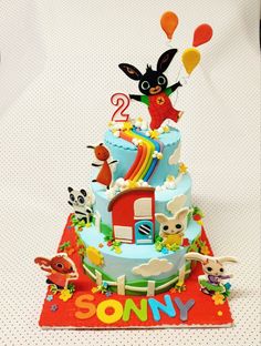 the birthday cake is decorated with animals and balloons