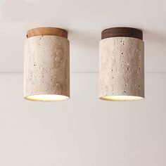 two concrete lamps are hanging from the ceiling