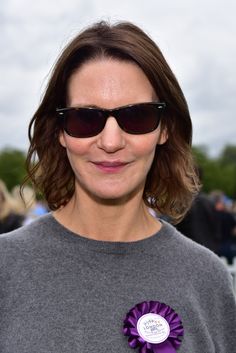 a woman wearing sunglasses and a purple ribbon around her neck