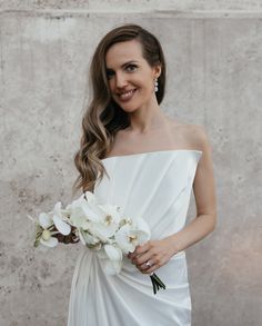 a woman in a white dress holding a bouquet of flowers