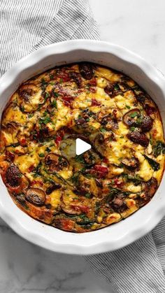 a white casserole dish filled with cheese and vegetables on a marble counter top