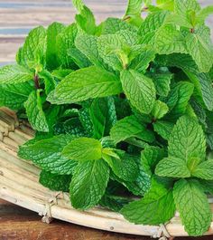 fresh mint leaves in a wicker basket on a wooden table, ready to be used as a garnish